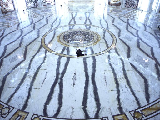 Woman shown splayed against black and white marble floor.