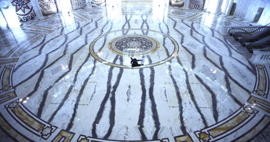 Woman shown splayed against black and white marble floor.