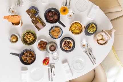 An view of a restaurant table seen from overhead with many colourful plates of traditional foods displayed