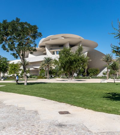 A view of The Park with trees, grass, walkways and the NMoQ building in the background