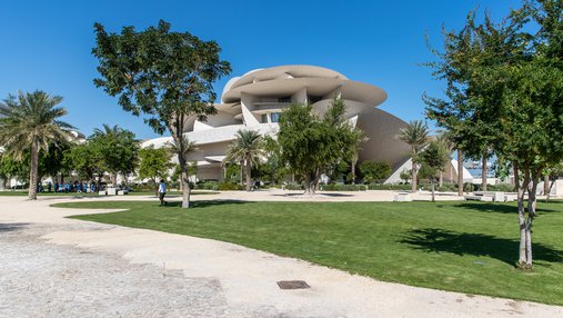 A view of The Park with trees, grass, walkways and the NMoQ building in the background