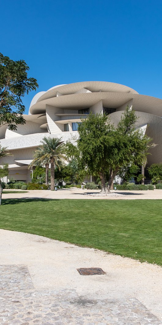 A view of The Park with trees, grass, walkways and the NMoQ building in the background