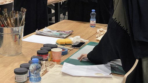 Artist in Residence Amna Al-Muftah demonstrating techniques to participants in the “Screen-printing Tote bags” workshop at the Fire Station.