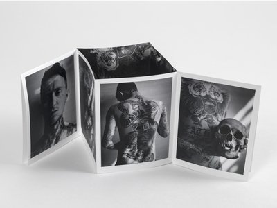 A foldout zine publication showing black and white images of a man and a skull..